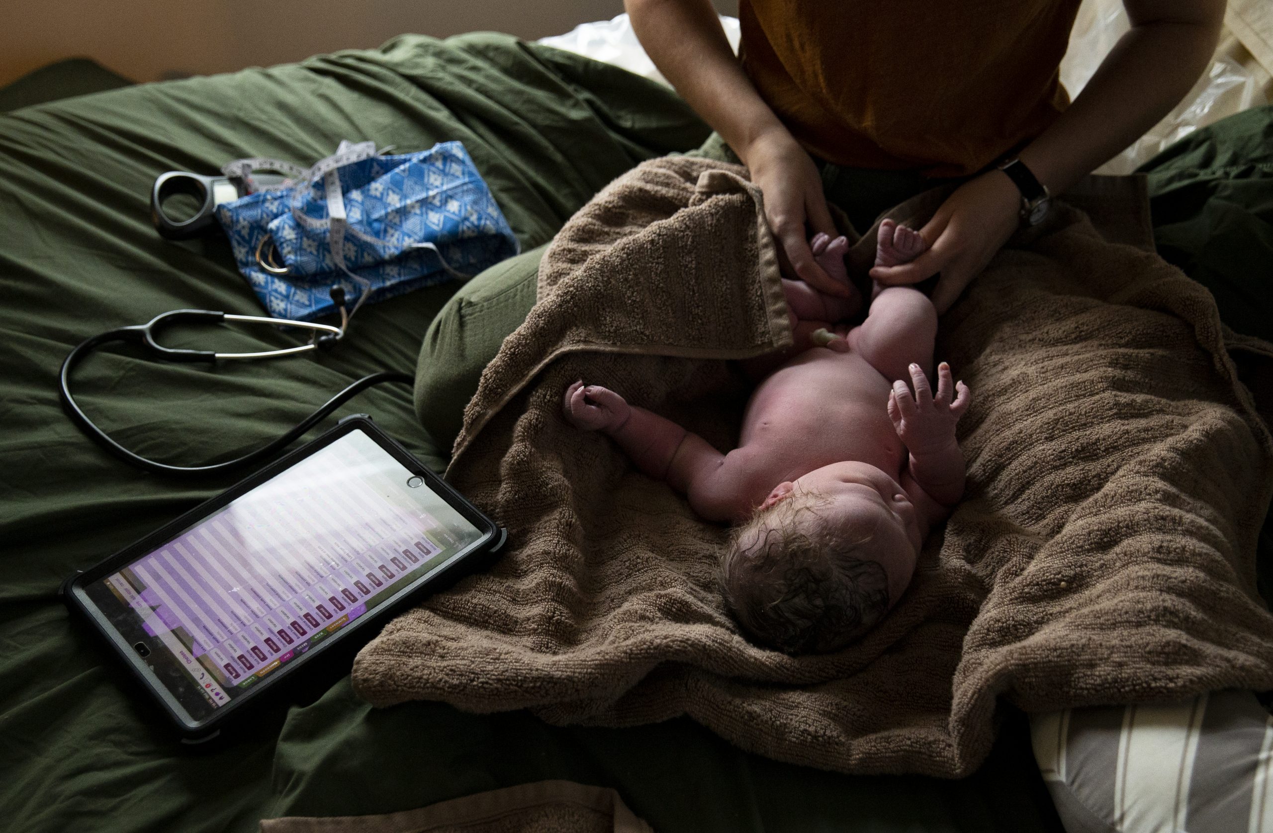 Senior certified professional midwife student Samantha Woolman does a post-birth exam June 14 on Avery Eggleston.