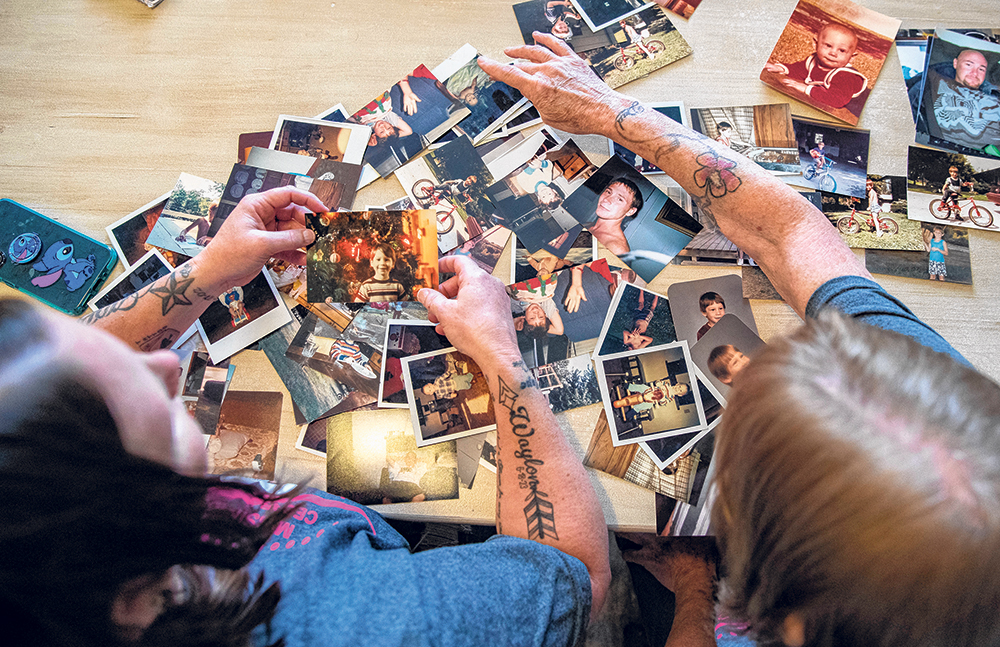 Josh Wellman’s mother, Teresa Walton, and sister, Shawna Hunziker, sort June 5 through photos of Josh throughout his childhood and adulthood at Shawna’s home in Vinton. Wellman has been missing since 2015.